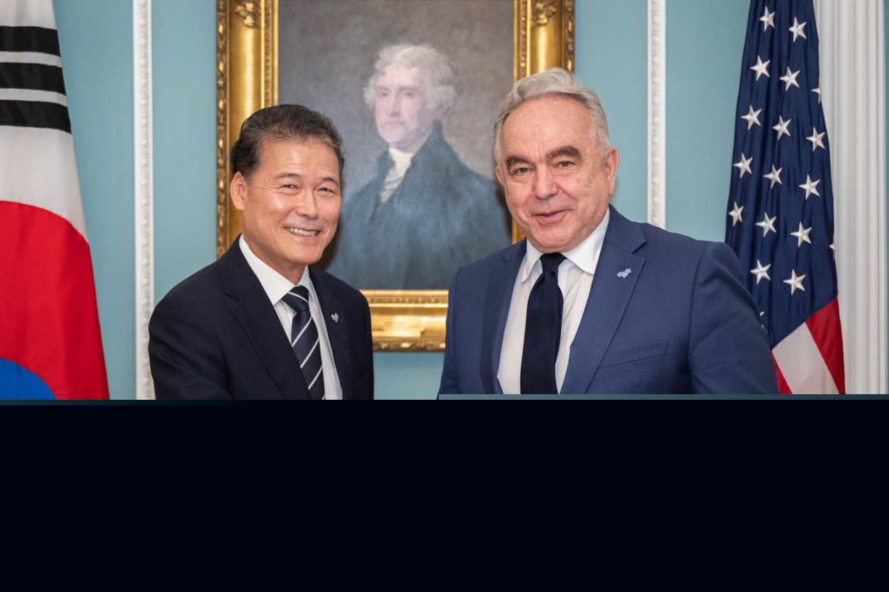 South Korea's Unification Minister Kim Yung-ho (left) and US Deputy Secretary of State Kurt Campbell (right) shake hands during a meeting in Washington on Monday. Both officials wear symbolic badges featuring three forget-me-not flowers, produced by the Unification Ministry. This emblem represents the