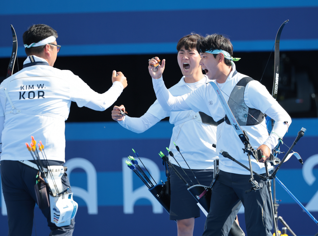 (From left) South Korea's men's archery team trio of Kim Woo-jin, Kim Je-deok and Lee Woo-seok cheer after defeating the home team France in the final held at Invalides in Paris on Monday. (Yonhap)